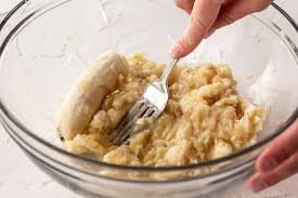 Mash and Mix: In a large mixing bowl, mash the bananas until smooth. Stir in the melted butter until well combined.