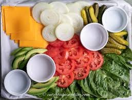 Lettuce, tomatoes, pickles, onions, and condiments such ketchup, mustard, and mayo make up toppings.